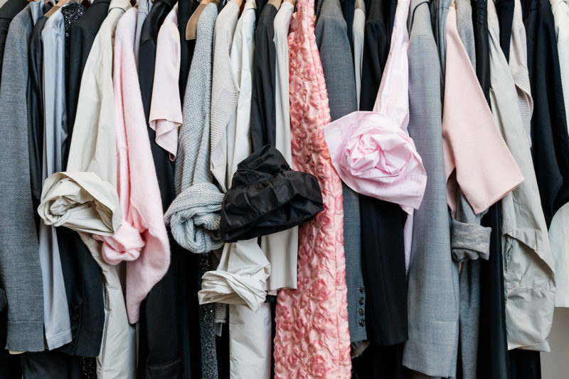 Garderobe mit neutralen Tönen, ergänzt durch schwarze und rosa Modeaccessoires